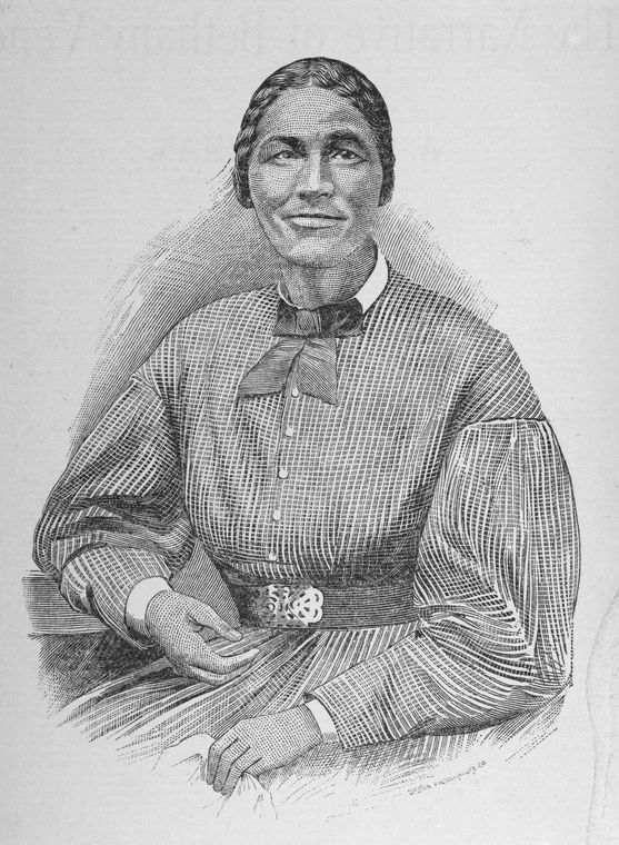 Bethany Veney seated and holding an item in her left hand.