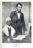 Sojourner Truth seated at a table with an open book on it. Abraham Lincoln stands next to Sojourner Truth and is looking at the book. 