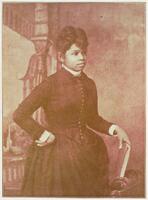 3/4 body photo of Annie L. Burton standing facing right, with her right hand holding a book and her left hand on her hip.