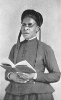 Julia A. J. Foote standing and holding an open book with both hands.