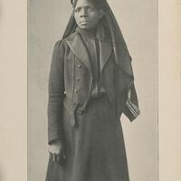 3/4 body photo of Susie King Taylor standing and facing front.