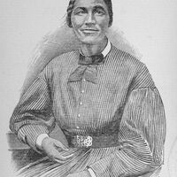 Bethany Veney seated and holding an item in her left hand.