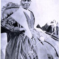 Sojourner Truth seated and facing front, She is holding yarn in one hand. 