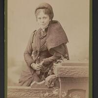 Sepia photograph of Hallie Quinn Brown standing, looking front.