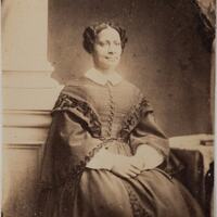 3/4 body photo of Sarah Parker Remond seated and facing front, her hands crossed in her lap.