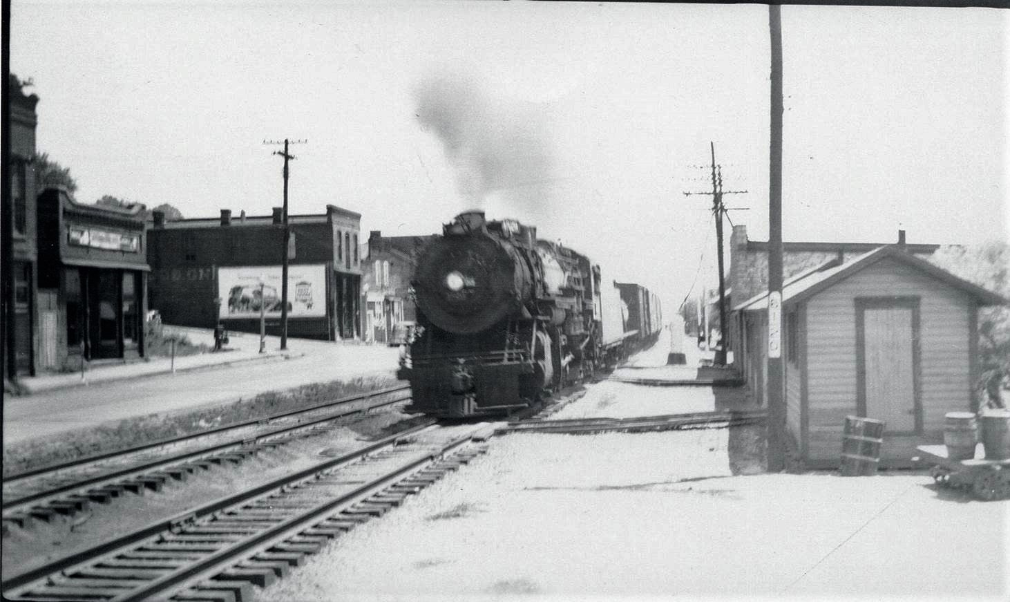 Photograph of a train traveling on railroad tracks in the riverfront business district, Chester, Illinois.