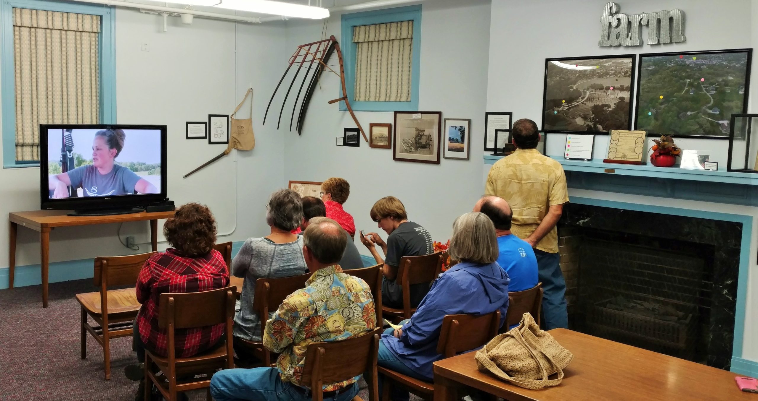 Photograph of people viewing a documentary video about local farm families, Chester Public Library.