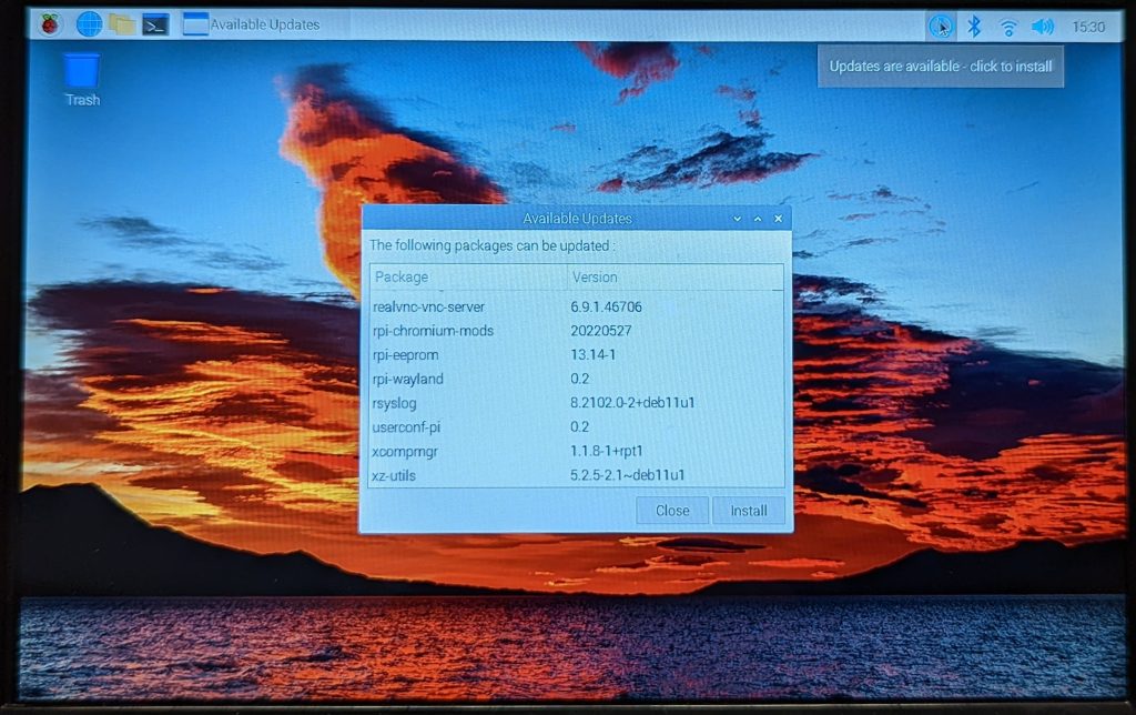 Screenshot of the Raspberry Pi OS desktop. The mouse pointer is hovering over the updates available icon at the upper right and a pop up stating updates are available. The update window is displayed on the desktop as the icon has been clicked.