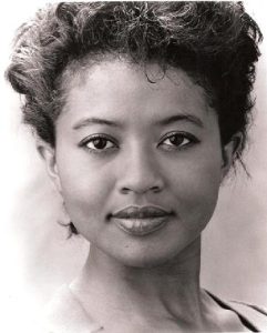 Houston with black upswept hair and a slim neck while facing the camera.