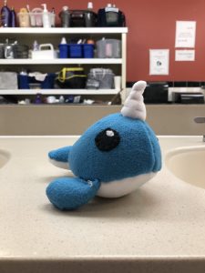 Blue narwhal plush on a sink countertop.
